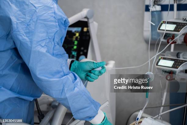 Doctor Dimitar Milutinov wearing protective equipment while taking measures the saturation of a COVID-19 patient's blood at the intensive care unit...