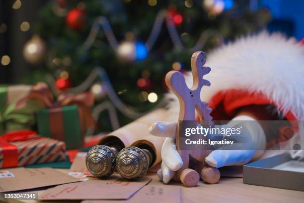 santa claus's hand in a white glove holding a wooden christmas tree toy. - white moose stock pictures, royalty-free photos & images