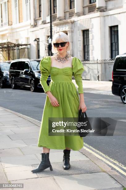 Stella Katterman wears a Nasty Gal dress, Mango bag, Zara sunglasses and Topshop boots during London Fashion Week September 2021 on September 18,...