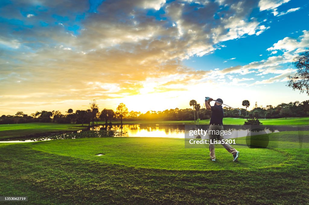 Homem em um lindo campo de golfe pôr do sol cênico balança um clube de golfe