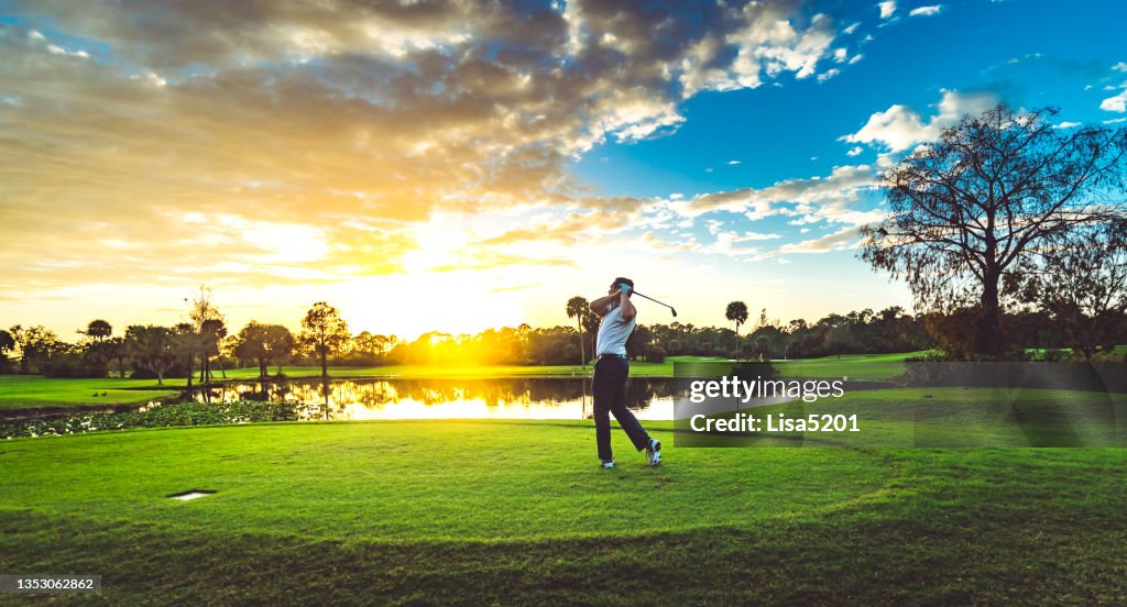 L’homme sur un magnifique parcours de golf pittoresque au coucher du soleil balance un club de golf