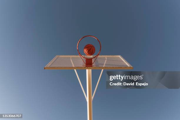 view from bottom of a basketball ball entering into the basket. - match basket stock pictures, royalty-free photos & images