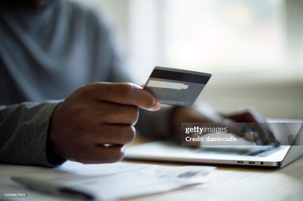 Man using credit card and laptop for online shopping