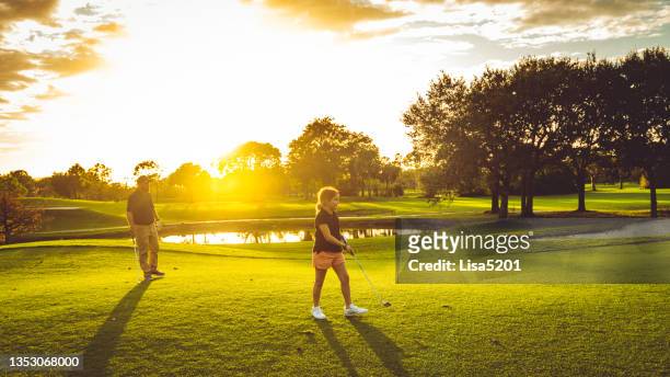 vater und tochter spielen mit der familie eine runde golf auf einem idyllischen golfplatz in südflorida - golf girls stock-fotos und bilder