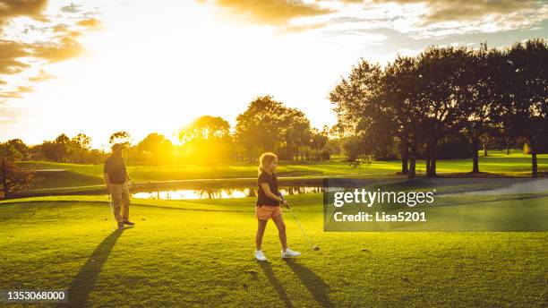 father and daughter playing a round of golf with family on an idyllic golf course in south florida - golf girls stock pictures, royalty-free photos & images