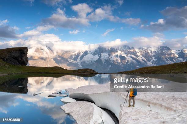 photographer takes some photos at grauseeli lake during sunset, switzerland - eiger mönch jungfrau stock pictures, royalty-free photos & images
