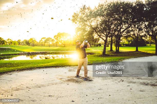 golfer tries to get out of a sand trap on scenic beautiful golf course in florida - golf bunker stock pictures, royalty-free photos & images