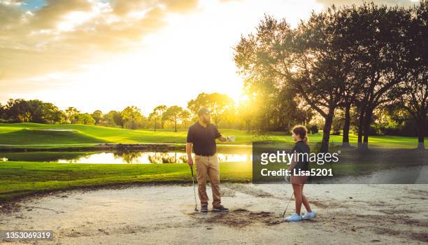 homme et fille, père et fille jouent au golf ensemble sur un parcours de golf pittoresque dans un piège à sable - father son challenge round two photos et images de collection