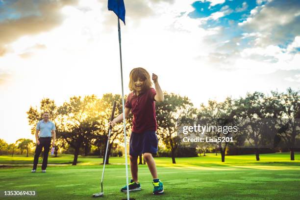 vater und kleine tochter auf dem golfplatz zusammen mädchen ist aufgeregt, sie hat ihren schuss gemacht, aktive familie - golf girls stock-fotos und bilder