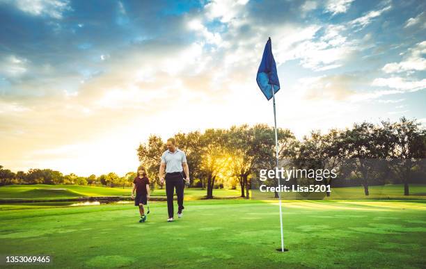 father and young daughter on the golf course together playing a round of golf with family - family golf stock pictures, royalty-free photos & images