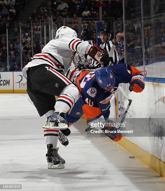Niklas Hjalmarsson of the Chicago Blackhawks hits Michael Grabner of the New York Islanders during the first period at the Nassau Veterans Memorial...