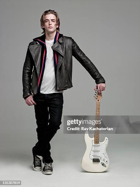 man standing holding guitar - leather jacket stock pictures, royalty-free photos & images