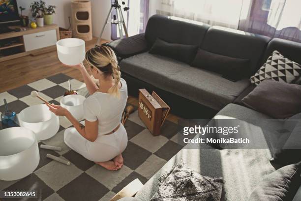 adult woman playing singing crystal bowl - feng shui house stock pictures, royalty-free photos & images