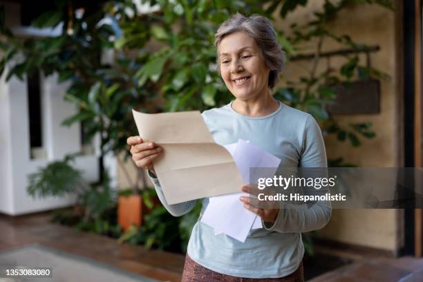 femme âgée heureuse lisant une lettre du courrier - courrier photos et images de collection