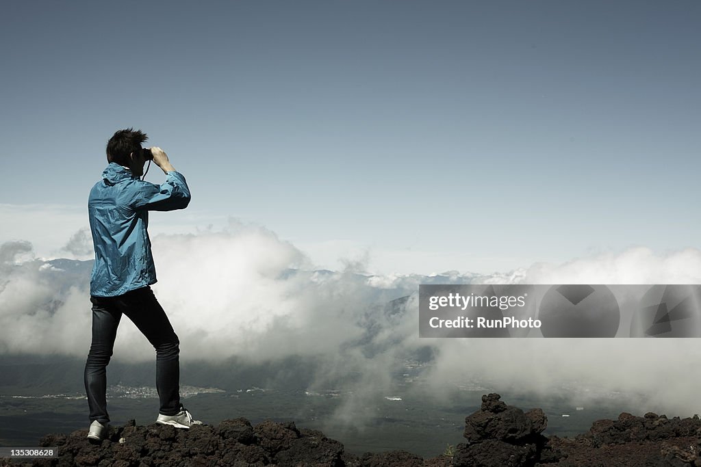 Man with binoculars at the mountain