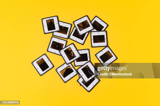 retro analog photography slides with black and white plastic frame with hard shadow, on yellow background. concept of analog photography, cinema, film, vintage and nostalgia. - rolling stock-fotos und bilder