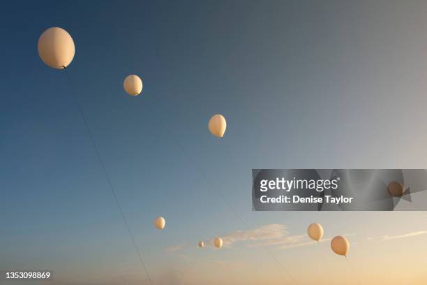 many white balloons against a blue sky - helium stockfoto's en -beelden