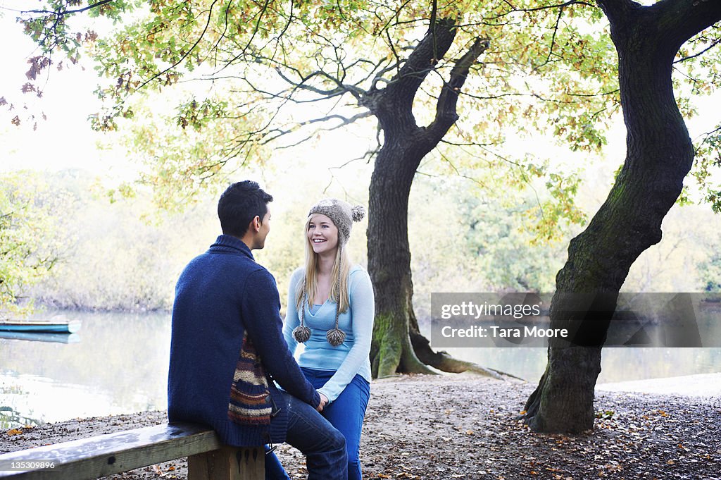 Young man and woman smiling in forest