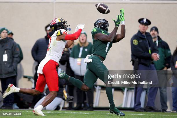 Jayden Reed of the Michigan State Spartans catches a touchdown pass against Tarheeb Still of the Maryland Terrapins in the first half at Spartan...