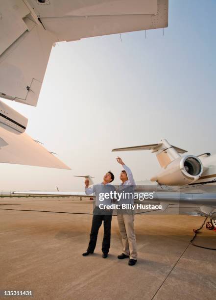 businessmen next to a private jet at an airport - chinese man looking up bildbanksfoton och bilder