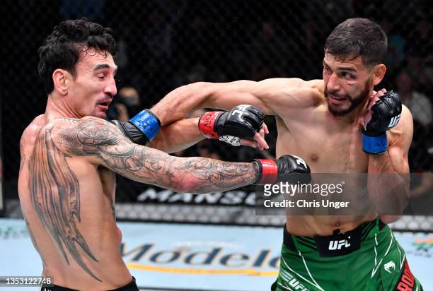 Yair Rodriguez of Mexico punches Max Holloway in a featherweight fight during the UFC Fight Night event at UFC APEX on November 13, 2021 in Las...