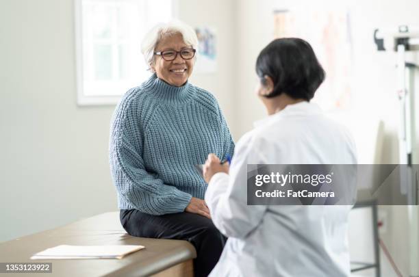 senior woman at the doctors - screening of netflixs what happened to monday arrivals stockfoto's en -beelden