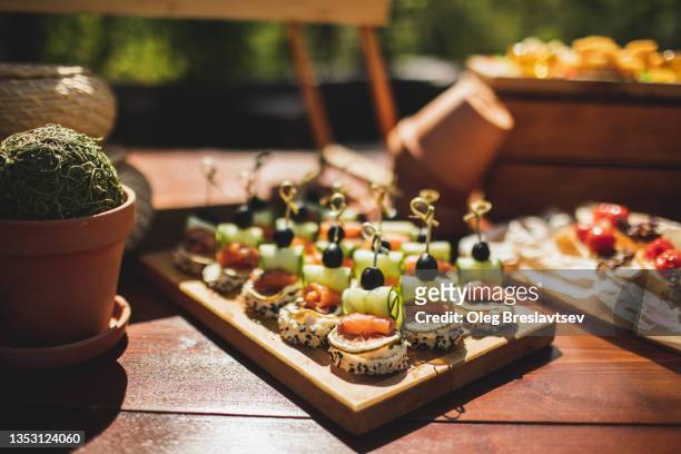 tasty canapes with salmon, cucumber, olives and whole grain bread. wedding catering - häppchen stock-fotos und bilder
