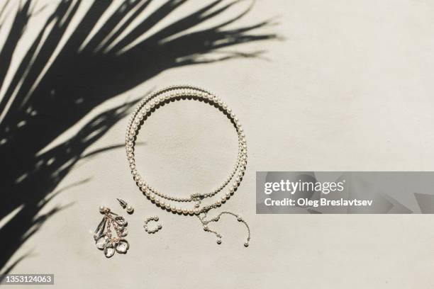 top view of woman jewelry accessories, pearl necklace and earrings with precious stones - diamante pedra preciosa - fotografias e filmes do acervo