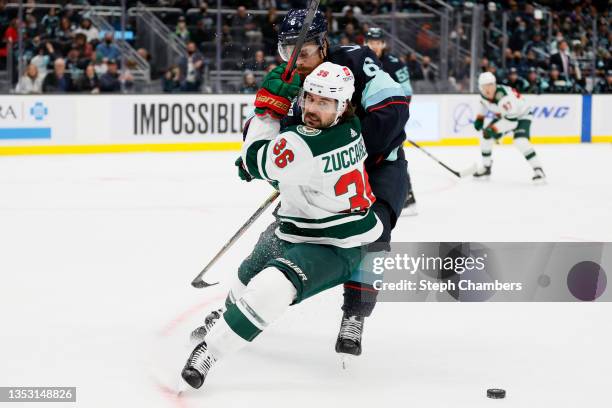 Mats Zuccarello of the Minnesota Wild is shoved by Adam Larsson of the Seattle Kraken during the first period on November 13, 2021 at Climate Pledge...