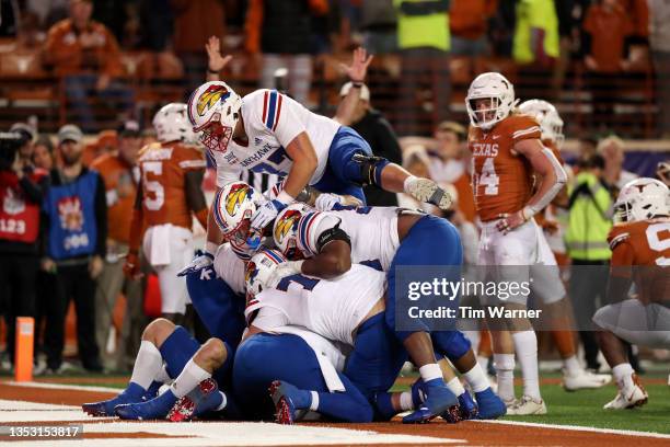 The Kansas Jayhawks celebrate in the end zone after a reception for a two point conversion in overtime by Jared Casey of the Kansas Jayhawks to...