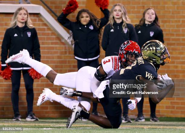 Donald Stewart of the Wake Forest Demon Deacons makes a catch against Aydan White of the North Carolina State Wolfpack during the second half of...