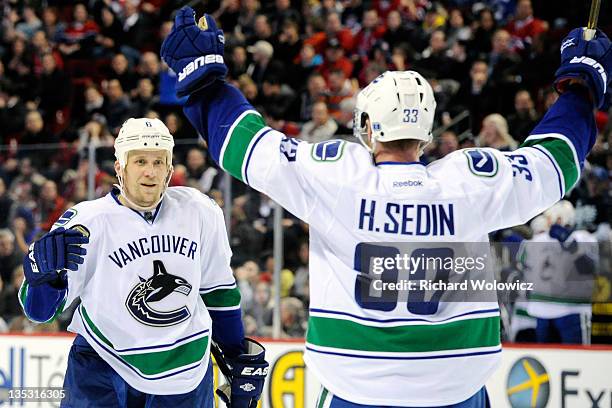 Sami Salo of the Vancouver Canucks celebrates his game tying goal with team mate Henrik Sedin during the NHL game against the Montreal Canadiens at...