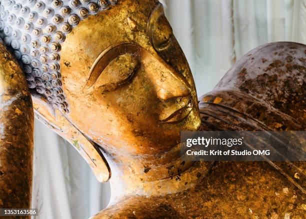 the golden sleeping buddha statue - reclining buddha stock-fotos und bilder