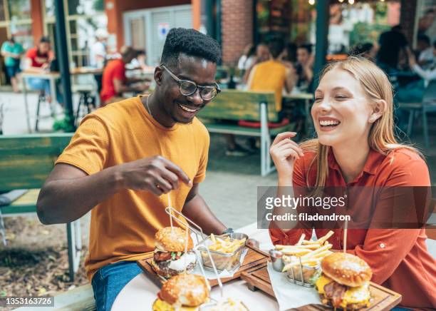 友人とファーストフード - man eating woman out ストックフォトと画像