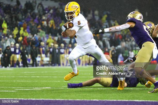 Jayden Daniels of the Arizona State Sun Devils breaks a tackle by Carson Bruener of the Washington Huskies to score a touchdown during the fourth...