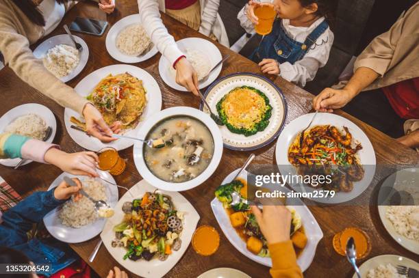 eine asiatische chinesische familie genießt ihr hausgemachtes essen während des chinesischen silvester-reunion-abendessens zu hause - chinese new year food stock-fotos und bilder