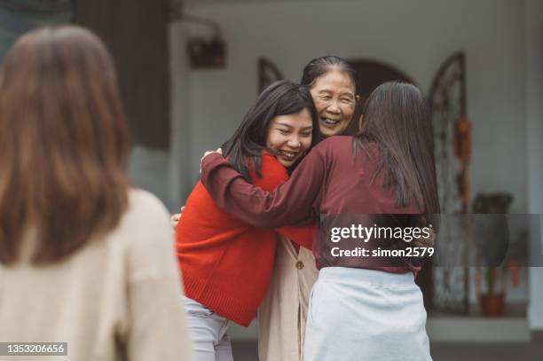 eine asiatische großmutter umarmt ihre tochter und enkelin mit liebe - alter wunsch fürs neue jahr stock-fotos und bilder