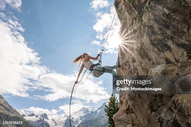 bergsteiger beim abseilen an felswand - rock climbing stock-fotos und bilder