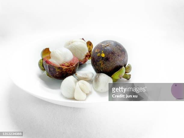 fresh mangosteen on a white plate - mangosteen stockfoto's en -beelden