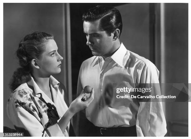 Actress Coleen Gray as 'Molly' holds a small ball and Actor Tyrone Power as 'Stanton/Stan Carlisle' looks at her in a scene from the movie 'Nightmare...