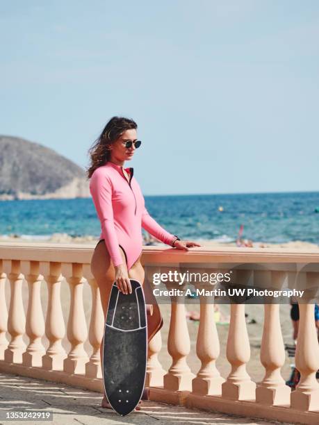 young skater girl wearing a pink swimwear and sunglasses near the beach - postureo fotografías e imágenes de stock