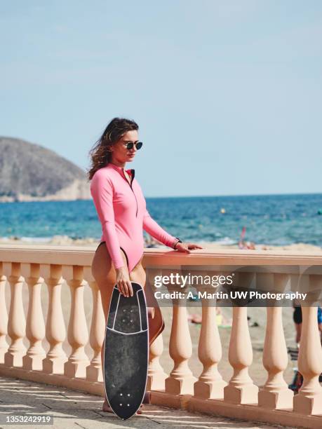 young skater girl wearing a pink swimwear and sunglasses near the beach - posa alternativa foto e immagini stock
