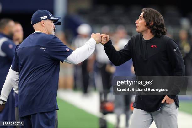 Defensive Coordinator of the Dallas Cowboys and former Atlanta Falcons head coach Dan Quinn fist bumps with a member of the Atlanta Falcons before...