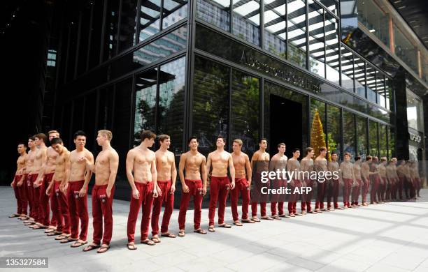 Abercrombie & Fitch models pose in a line outside the A&F store in Knightsbridge, a Singapore shopping mall on December 9, 2011. A&F's first...