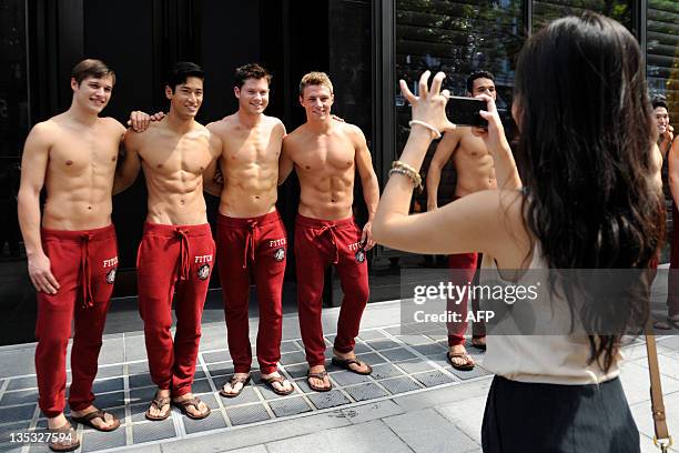 Passerby takes a picture of Abercrombie & Fitch models outside the A&F store in Knightsbridge, a Singapore shopping mall on December 9, 2011. A&F's...