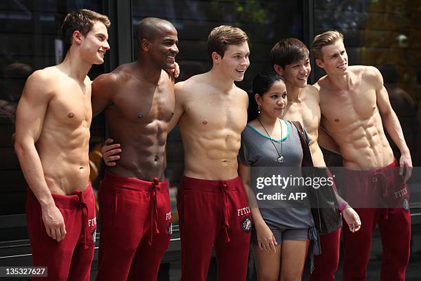 Passerby has her picture taken with Abercrombie & Fitch models outside the A&F store in Knightsbridge, a Singapore shopping mall on December 9, 2011....