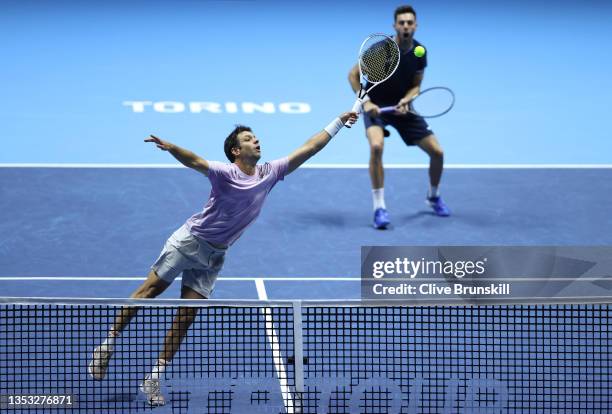 Marcel Granollers of Spain plays a volley as partner Horacio Zeballos of Argentina looks on during their doubles match against Filip Polasek of...