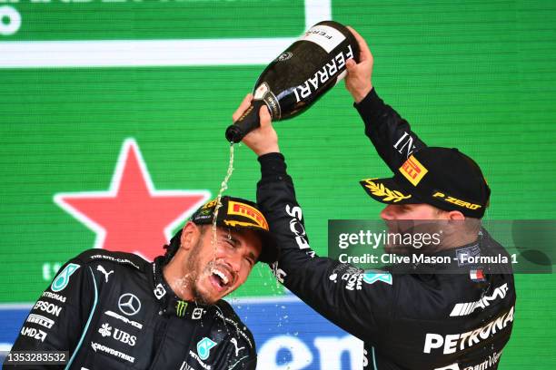 Race winner Lewis Hamilton of Great Britain and Mercedes GP and third placed Valtteri Bottas of Finland and Mercedes GP celebrate with sparkling wine...