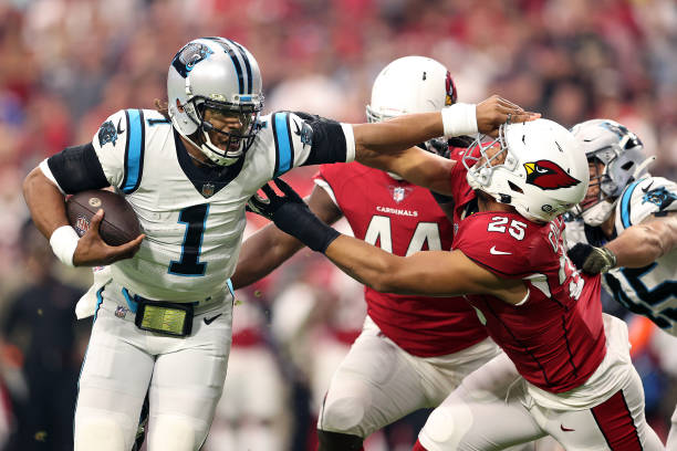 Cam Newton of the Carolina Panthers rushes the ball for a touchdown against Zaven Collins of the Arizona Cardinals in the first quarter at State Farm...