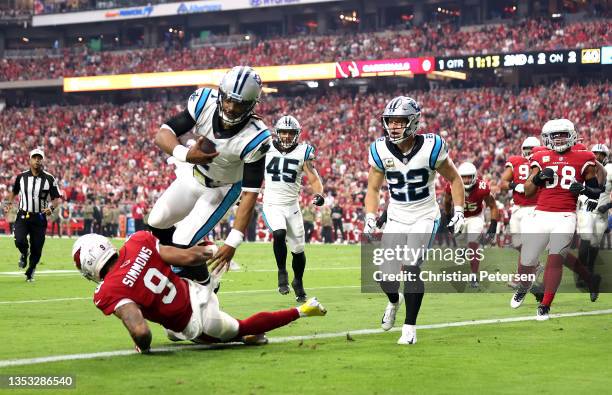 Cam Newton of the Carolina Panthers dives into the end zone for a touchdown over Isaiah Simmons of the Arizona Cardinals in the first quarter at...